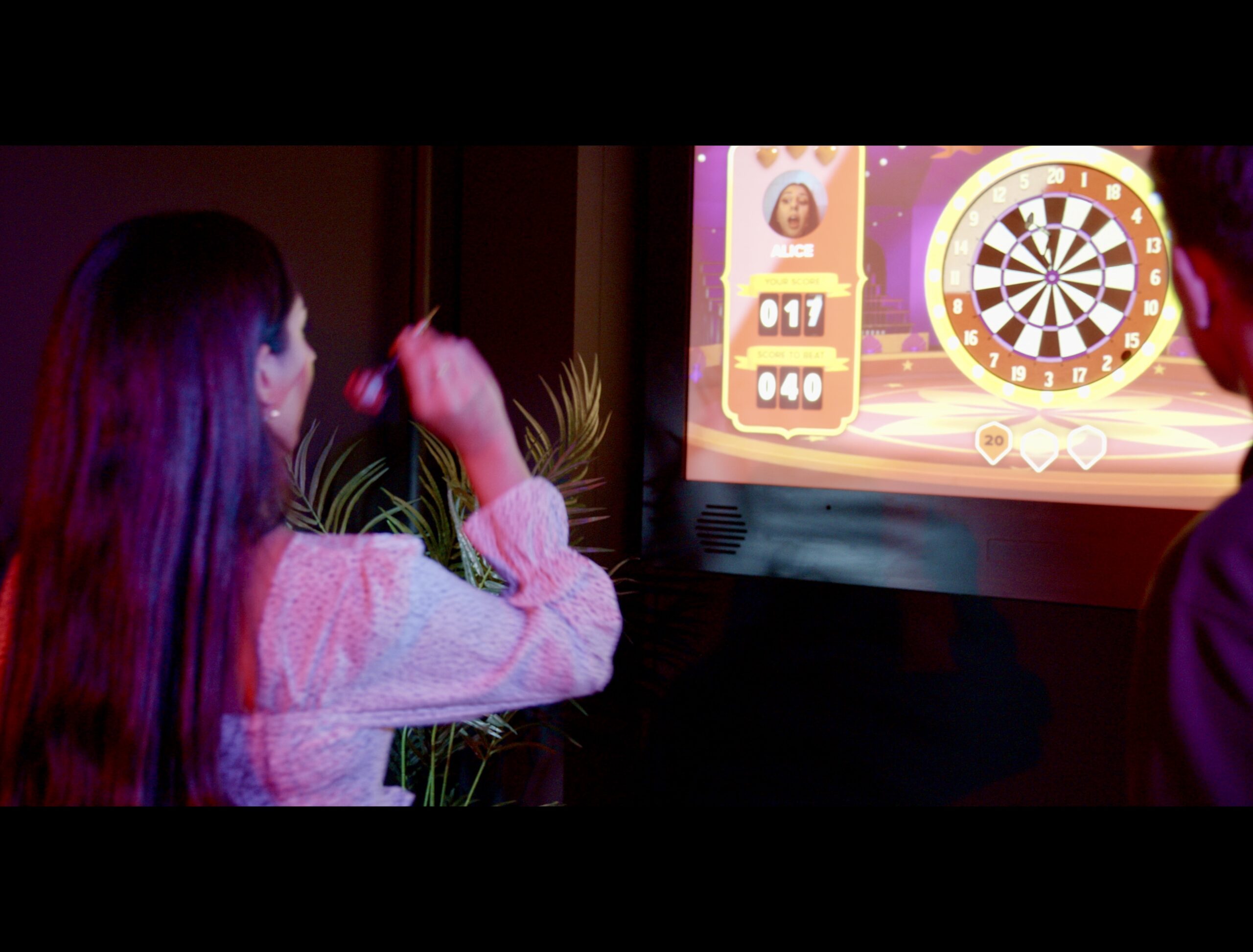 woman aiming her dart at a dart board at High 5 Austin